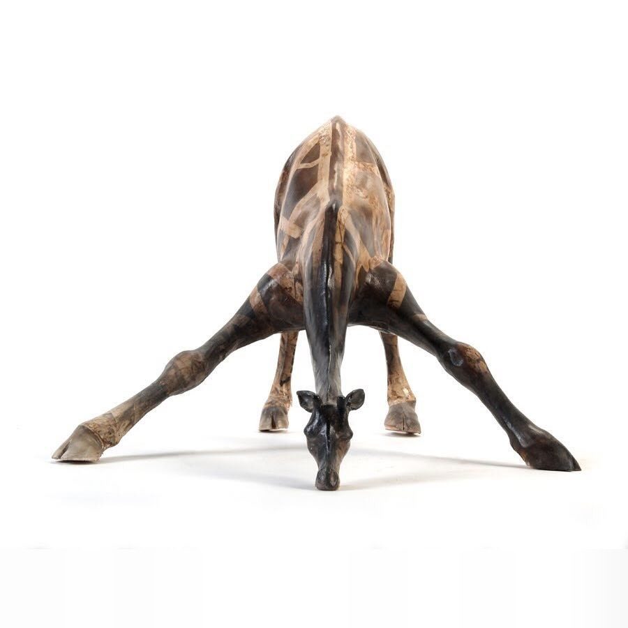 Sculpture de girafe en céramique, penchée pour boire